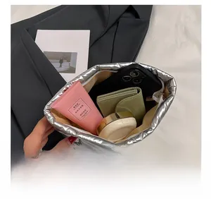 Inside view of silver metallic cosmetic bag showing capacity for phone and makeup