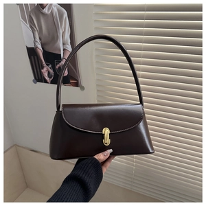 Detailed view of deep brown vintage baguette bag with gold pill-shaped metal buckle