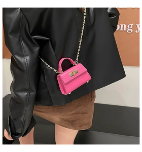 Detailed view of fuchsia crocodile pattern mini bag with gold chain and twist lock