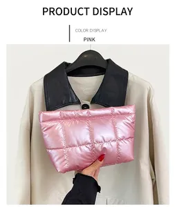 Detail of pink quilted handheld cosmetic bag with glossy metallic finish texture