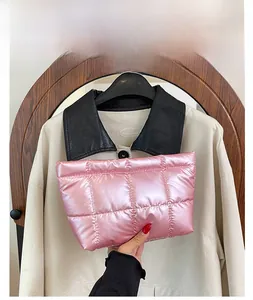 Detail of pink quilted handheld cosmetic bag with glossy metallic finish texture