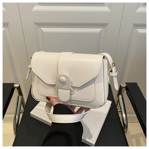 Close-up of creamy white leather square bag with gold hardware and stylish round buckle