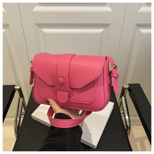 Detail of hot pink crossbody bag showing matte texture and matching adjustable strap