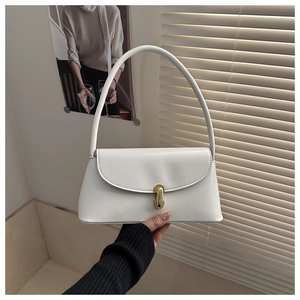 Close-up of white faux leather baguette bag with elegant gold buckle and slim straps