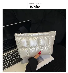 Close-up of white quilted puffer cosmetic bag with checkered stitching and zipper detail