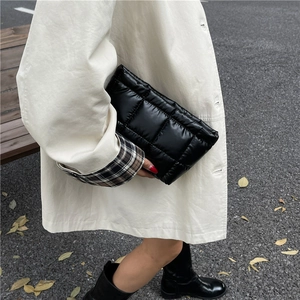 Chic black quilted clutch bag featuring puffy square stitching and lightweight nylon fabric