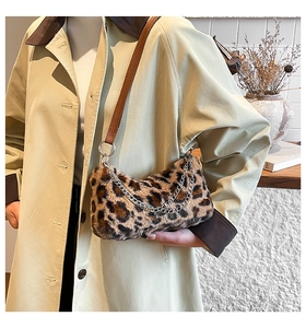 Dettaglio borsa di peluche leopardata con catene argentate e tracolla in pelle su modella