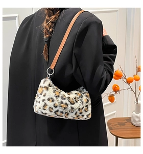 Détail d'un sac en fausse fourrure léopard avec anse en cuir marron et chaîne en métal argenté