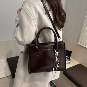 Grand sac cabas chic marron foncé en cuir brillant avec un pendentif élégant