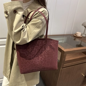 Elegante borsa tote bordeaux con stampa leopardata da donna indossata a tracolla