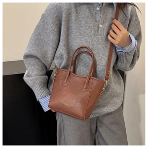 Detail showing the brown PU leather tote bag with adjustable shoulder strap and gold lettering