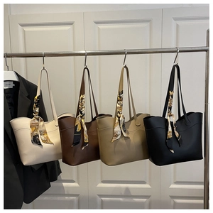 Hanging display of large bucket tote bags in four colors with decorative silk scarves
