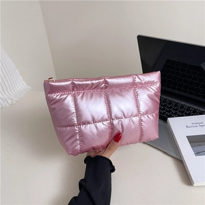 Trousse à maquillage matelassée rose métallisé en duvet avec fermeture éclair sur bureau