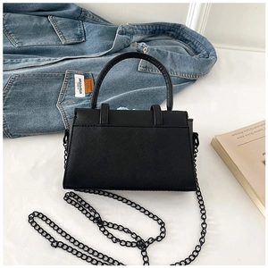 Detail of black cross-grain leather crossbody bag with metallic chain strap and top handle