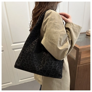 Detailed close-up of the black leopard pattern and matte canvas texture on this tote bag