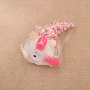 Detail view of pink sequin gnome plush base showing a battery compartment with white cover
