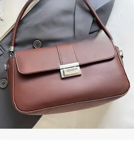 Detail of dark brown leather underarm bag featuring polished silver metal hardware