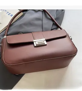 Detail shot of a dark brown matte leather underarm bag with silver rectangular metal buckle