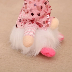 Close-up of a pink sequined gnome with white plush beard and striped details