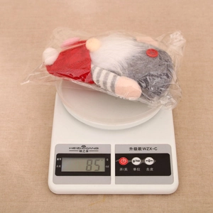 Detailed view of a Christmas heart gnome plush on a scale weighing 85 grams