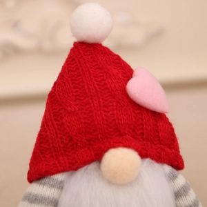 Close-up of knit heart hat and white faux fur beard on festive gnome decoration