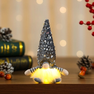 Detail of grey glowing gnome with silver sequin hat and warm LED light in festive setting