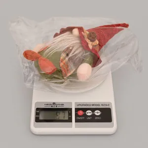 Close-up of a Christmas gnome plush weighting 97g on an electronic scale for dimensioning