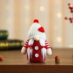 Detailed view of a Christmas gnome doll with white knitted hat and red heart decor