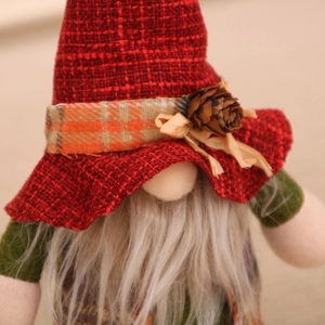 Close-up of Christmas gnome featuring a red burlap hat with pine cones and long white beard