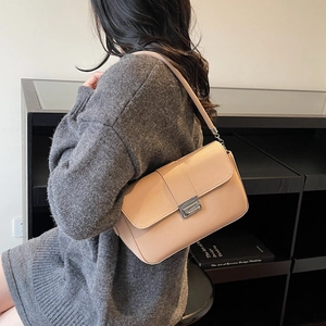 Minimalist light pink crossbody bag with silver buckle and chain strap on a model