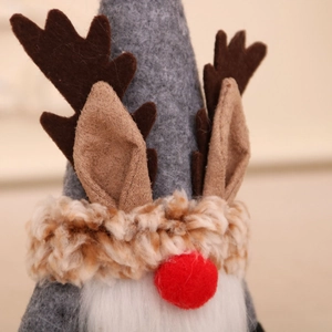 Close-up of Christmas gnome with reindeer antlers, felt hat and soft white beard detail