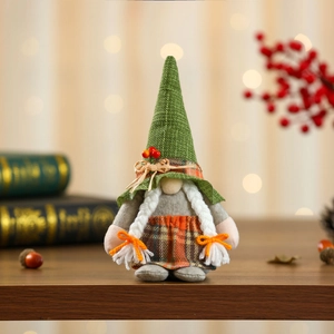 Macro view of green knit hat and red berries on a Swedish gnome plush harvest decoration