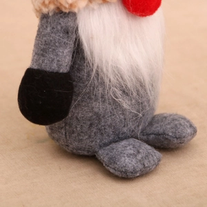 Close-up of Nordic Christmas gnome featuring grey felt body and plush white beard texture