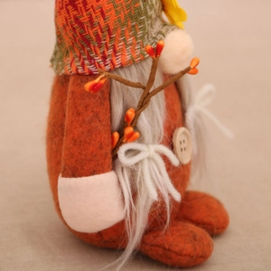 Détail d'un gnome d'automne avec corps en feutre orange et chapeau en tricot vert