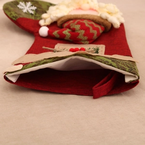 Detail of oversized linen Christmas stocking with 3D Santa and snowflake patch