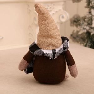 Close-up back view of a plush coffee gnome with burlap hat and black white plaid scarf