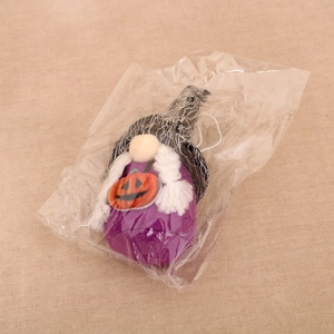 Detail of Halloween gnome plush toy in OPP packaging with purple body and pumpkin decor