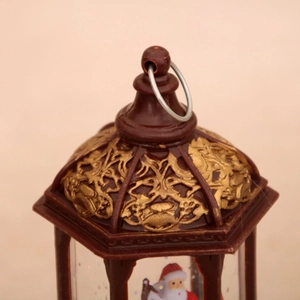 Detail of vintage gold embossed Christmas lantern top with metal ring and Santa scene
