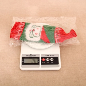 Detailed knit wine bottle cover with festive patterns weighing 28g on a digital scale