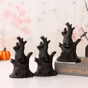 Detailed close-up of spooky black ghost tree figurines with RIP gravestones for Halloween