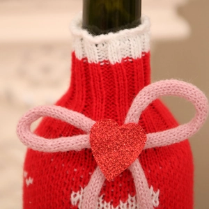 Détail d'un cache-bouteille tricoté avec cœur scintillant pour décoration de fête