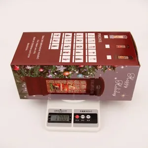 Detailed view of the Christmas phone booth lantern being weighed on a digital scale