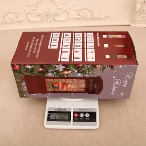 Detailed view of the Christmas phone booth lantern being weighed on a digital scale