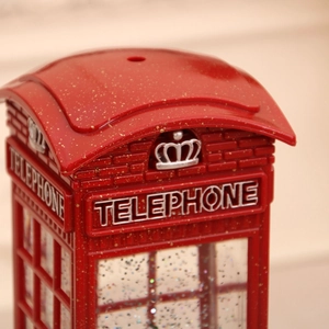 Close-up of a red Christmas telephone booth with glitter accents and silver crown detail