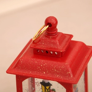 Close-up of red Christmas lantern with gold glitter finish and metal handle