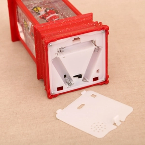 Detail view of the red Christmas lantern base showing the battery compartment and speaker