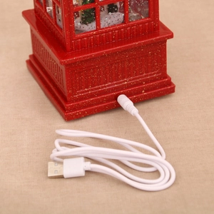 Detail of red Christmas phone booth base with gold glitter and USB power cable connection
