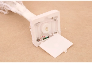 Close-up of the battery compartment and white snow fiber base of a Christmas tree decoration