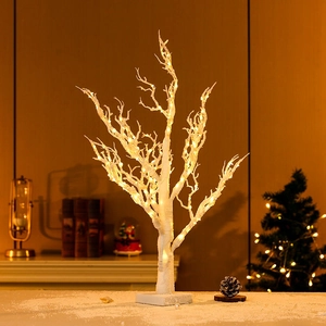 Detail of white birch LED tree with warm yellow lights and minimalist square base
