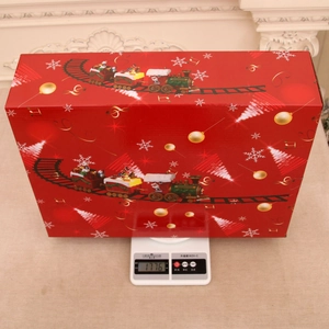 Detailed view of red Christmas train set gift box weighing 1776g on digital scale